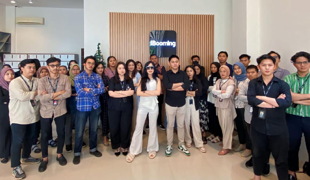  A group of people posing for a photo in front of a wall with the iBooming logo.